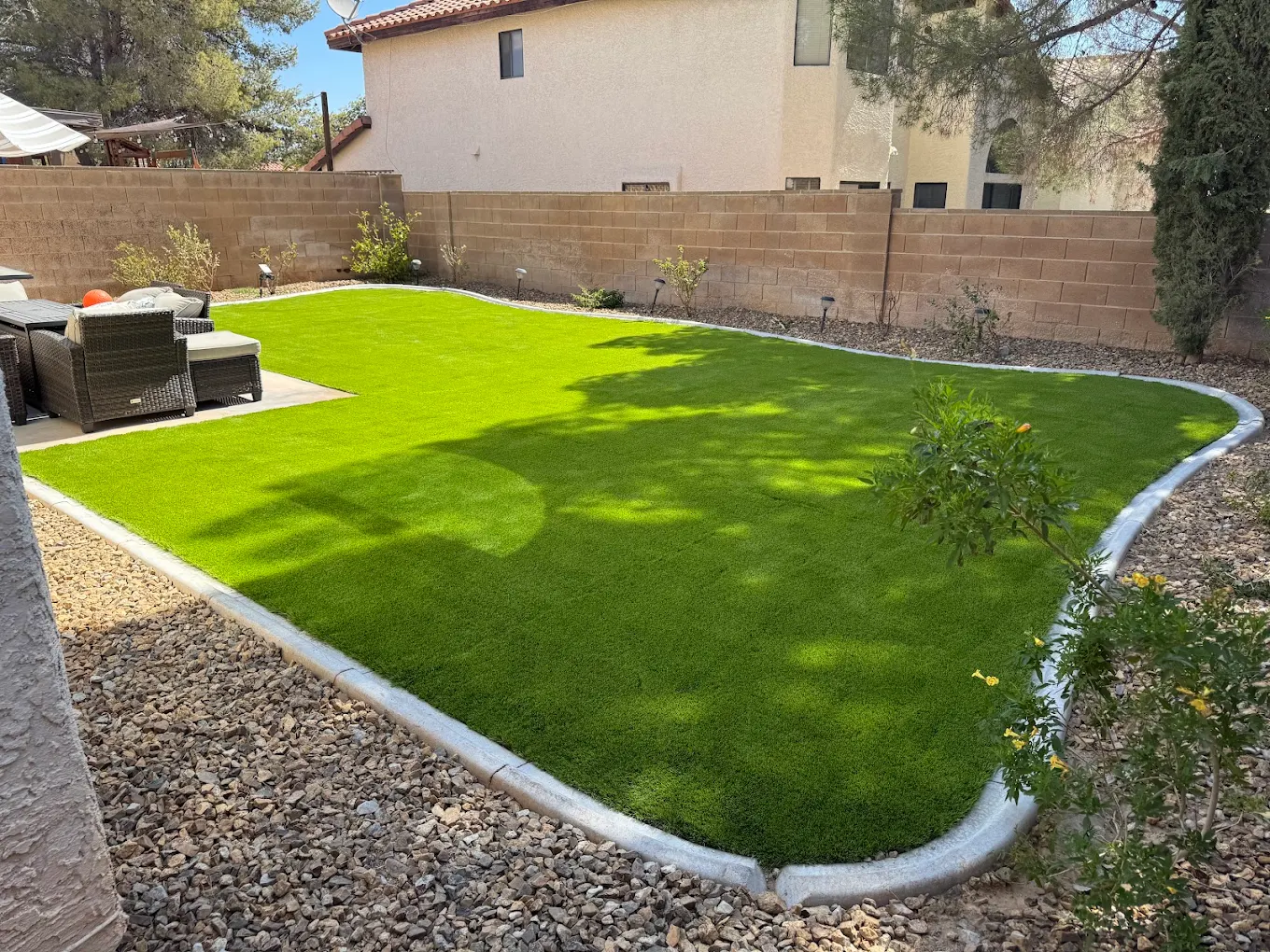 Artificial turf installation showing gravel edging and base preparation in a San Diego backyard