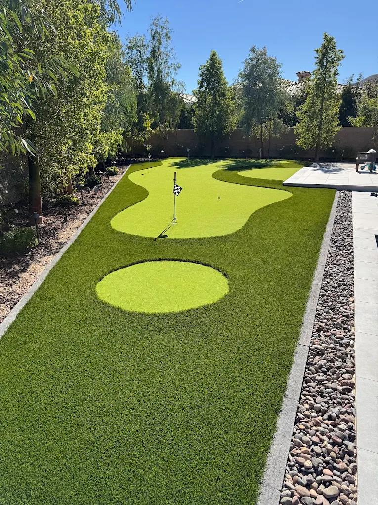 Artificial turf putting green with decorative rock xeriscaping in San Diego