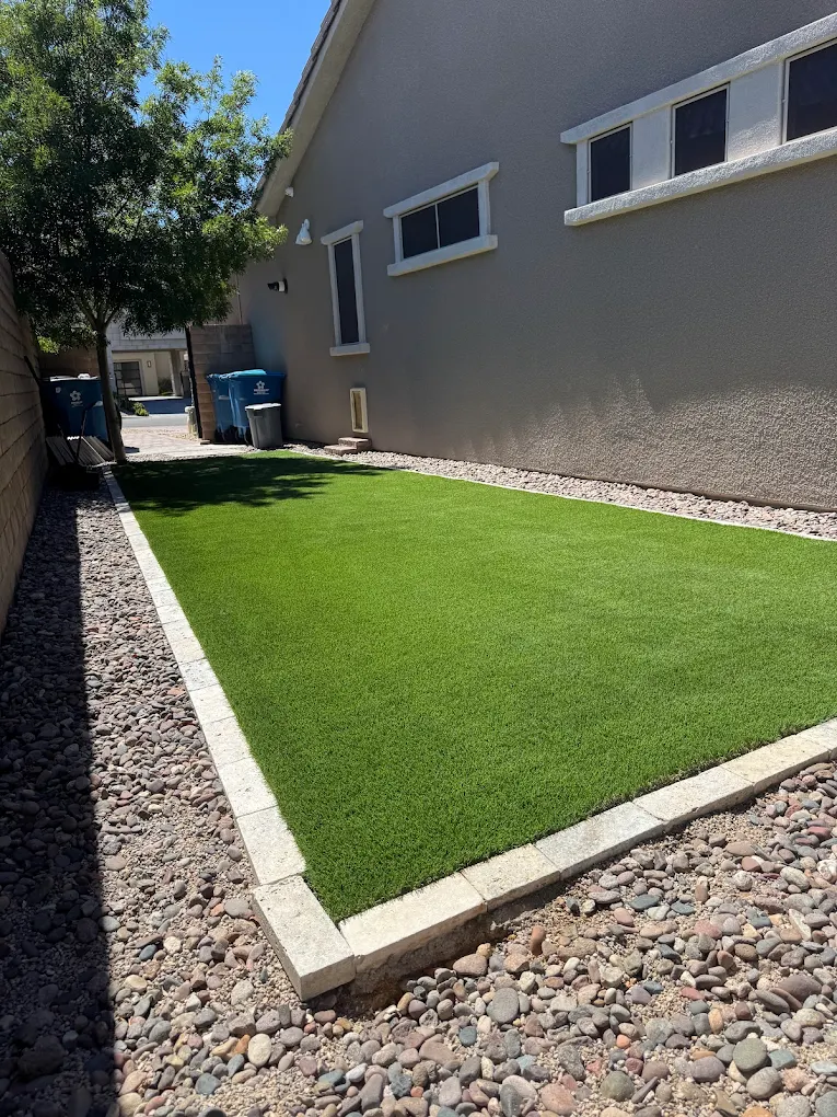 Side yard artificial turf installation with gravel border on San Diego area soil
