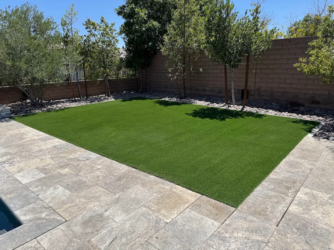 Artificial turf with paver border installed according to San Diego building standards